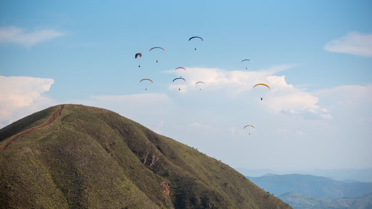 Scenic view of paragliders soaring above lush greenery in Brumadinho, Minas Gerais, Brazil.